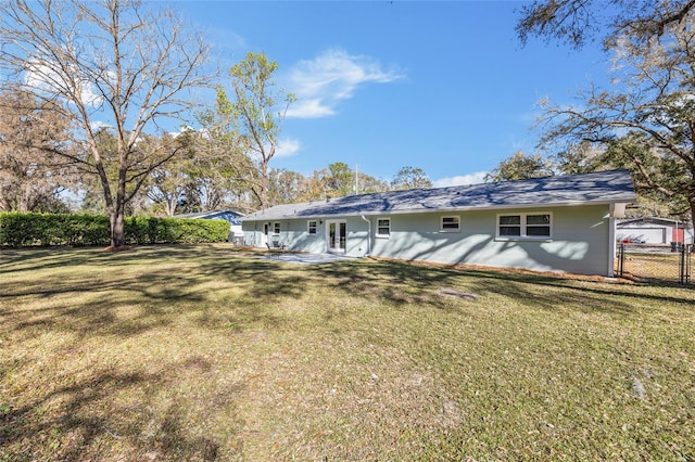 back of house with fence and a lawn