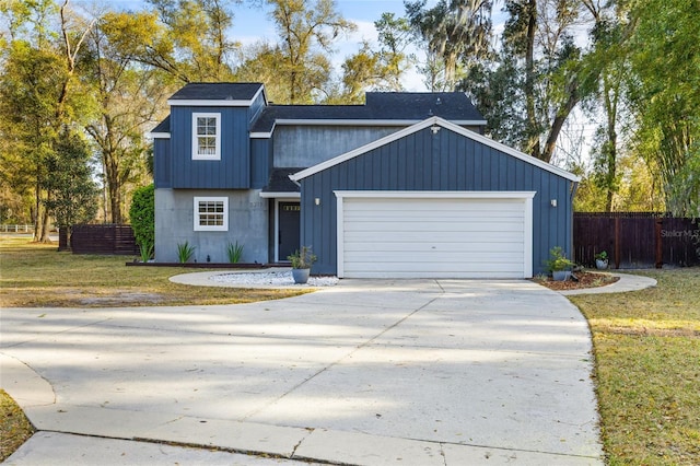 view of front facade with driveway, a garage, fence, and a front lawn