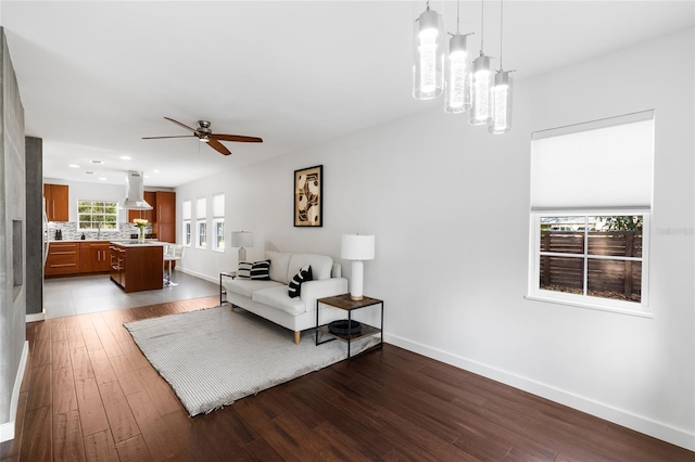 living area featuring ceiling fan, recessed lighting, wood finished floors, and baseboards