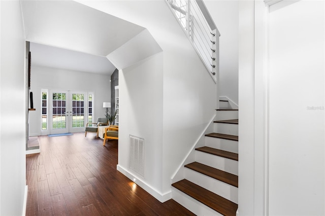 staircase with baseboards, visible vents, hardwood / wood-style floors, and french doors