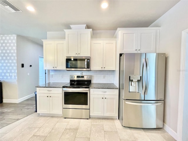 kitchen with visible vents, appliances with stainless steel finishes, tasteful backsplash, and dark stone countertops