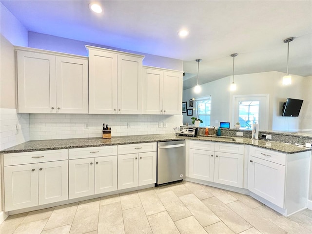 kitchen featuring dark stone countertops, a peninsula, hanging light fixtures, stainless steel dishwasher, and backsplash