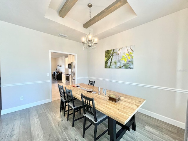 dining room featuring light wood finished floors, visible vents, and baseboards