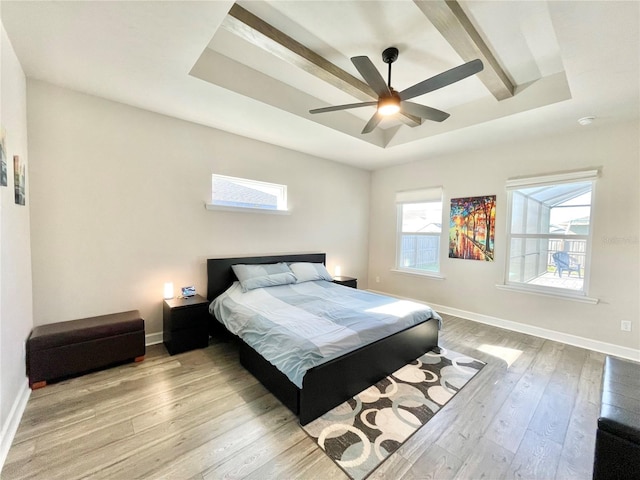 bedroom with baseboards, a tray ceiling, ceiling fan, and wood finished floors