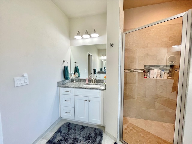 bathroom featuring a stall shower, vanity, and baseboards