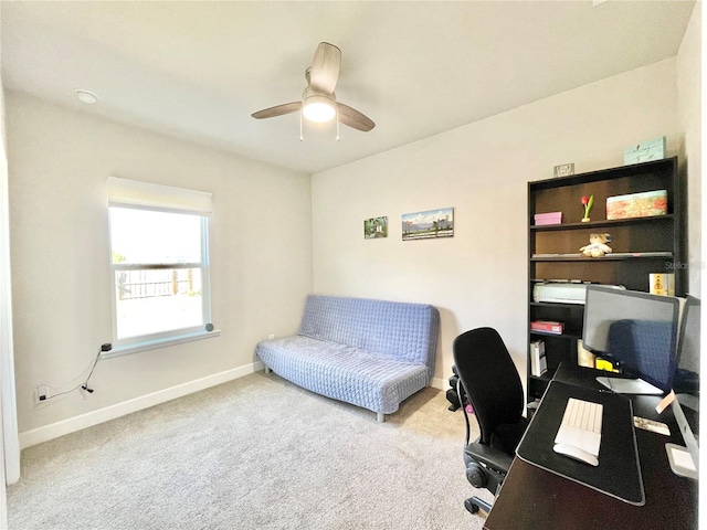 carpeted home office with ceiling fan and baseboards