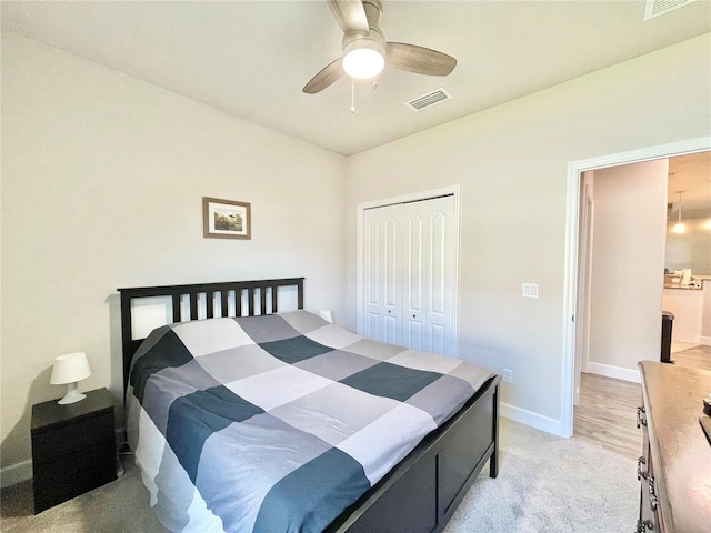 bedroom with a closet, visible vents, a ceiling fan, light carpet, and baseboards