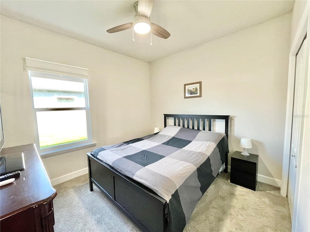 carpeted bedroom with ceiling fan and baseboards