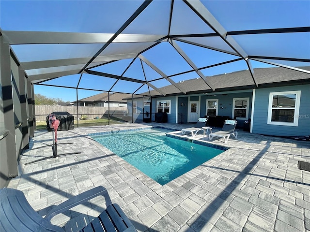 view of swimming pool with a fenced in pool, glass enclosure, a patio, and fence