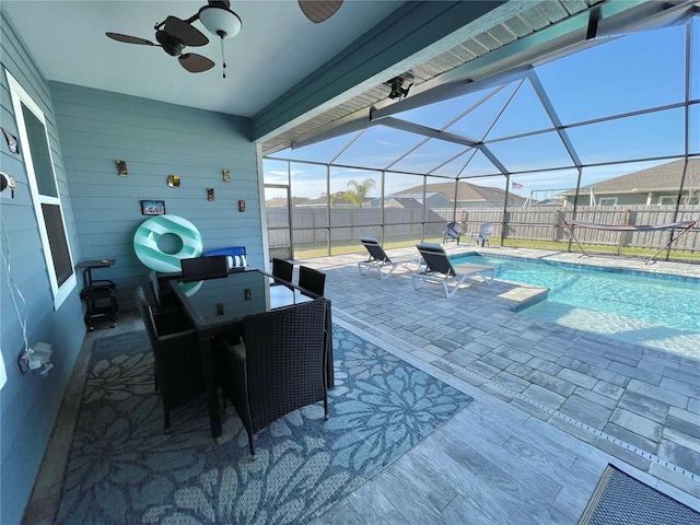 view of swimming pool featuring a fenced in pool, a patio, a ceiling fan, glass enclosure, and a fenced backyard