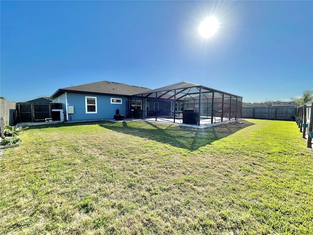 rear view of property with a lanai, a fenced backyard, a lawn, and a patio