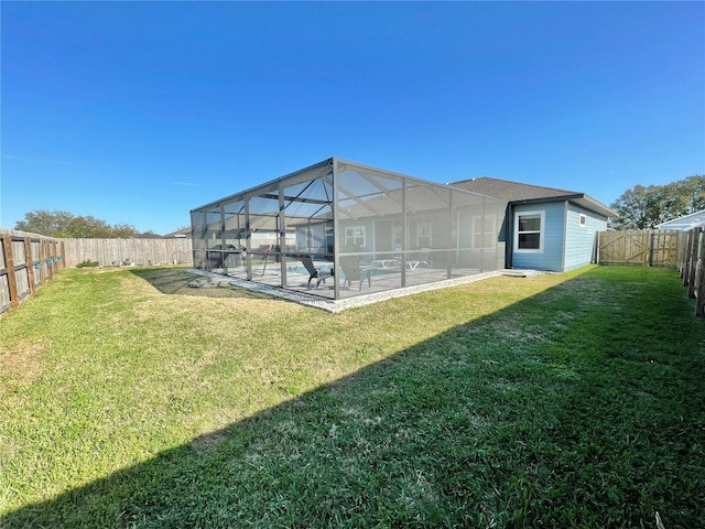 back of property featuring a yard, a fenced backyard, a fenced in pool, and a lanai