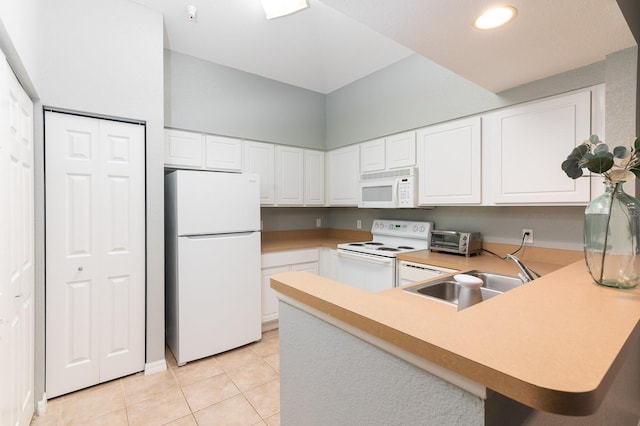 kitchen with white appliances, white cabinets, a peninsula, a sink, and light tile patterned flooring