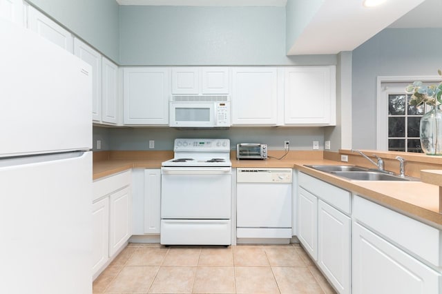 kitchen with light tile patterned floors, white appliances, a sink, white cabinetry, and light countertops