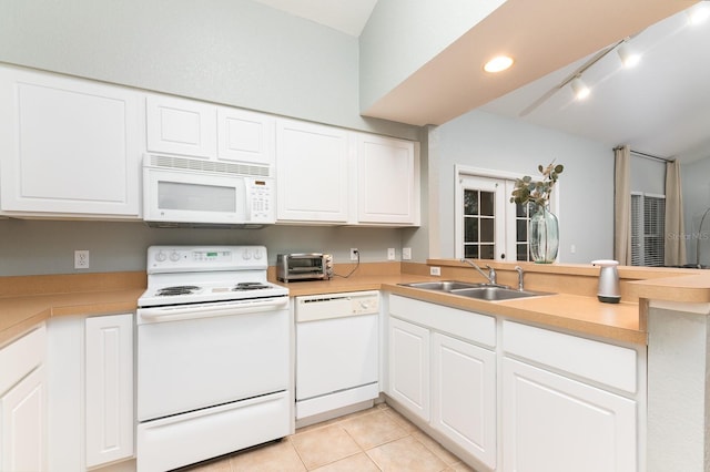 kitchen featuring light tile patterned floors, light countertops, a sink, white appliances, and a peninsula