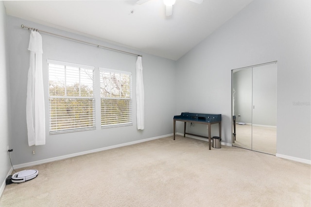 interior space with vaulted ceiling, baseboards, and ceiling fan