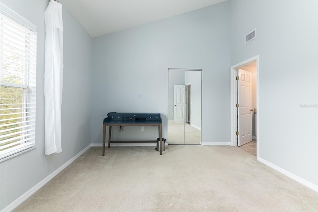 carpeted bedroom with high vaulted ceiling, baseboards, multiple windows, and visible vents