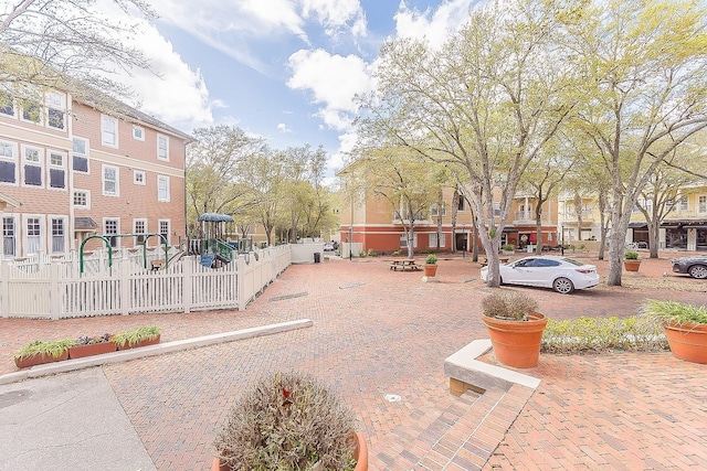 view of property's community with playground community and fence