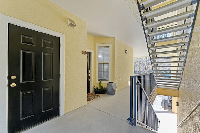 doorway to property featuring stucco siding and a balcony