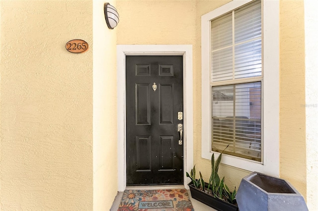 entrance to property with stucco siding