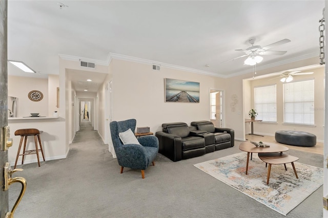 living room with carpet flooring, a ceiling fan, visible vents, and ornamental molding