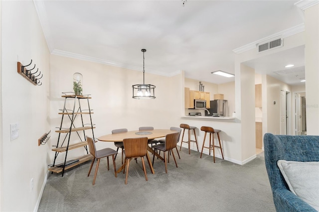 dining room with visible vents, carpet floors, baseboards, and crown molding