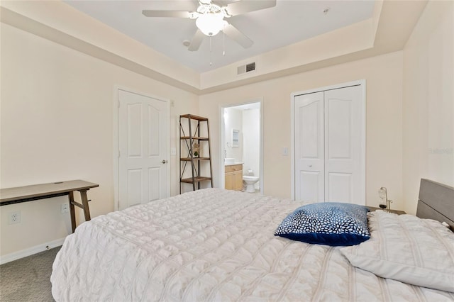 carpeted bedroom with visible vents, ensuite bath, a closet, baseboards, and ceiling fan