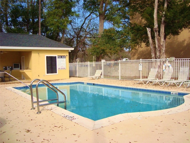 pool with a patio area and fence