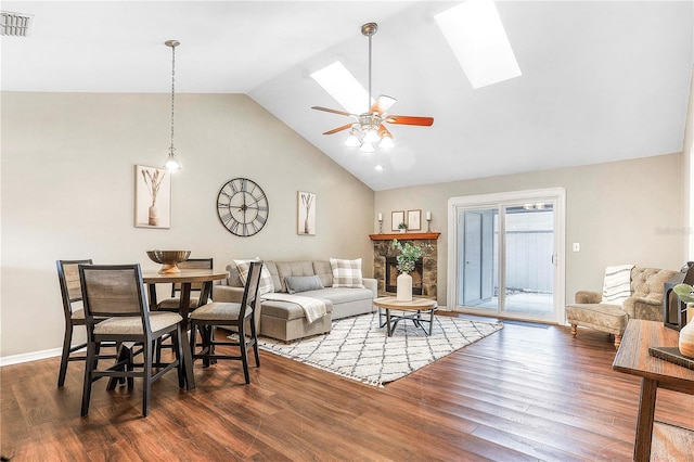 living room with a skylight, visible vents, ceiling fan, wood finished floors, and high vaulted ceiling