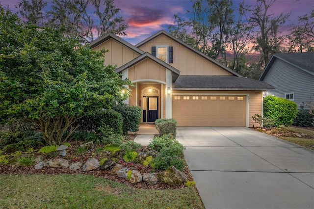 craftsman house featuring a garage, concrete driveway, board and batten siding, and roof with shingles