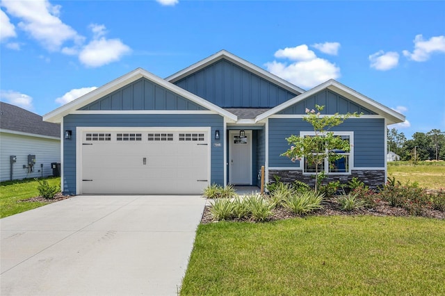 view of front of home with an attached garage, stone siding, concrete driveway, a front lawn, and board and batten siding