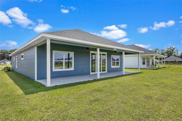 back of property featuring a patio, roof with shingles, a lawn, and a ceiling fan