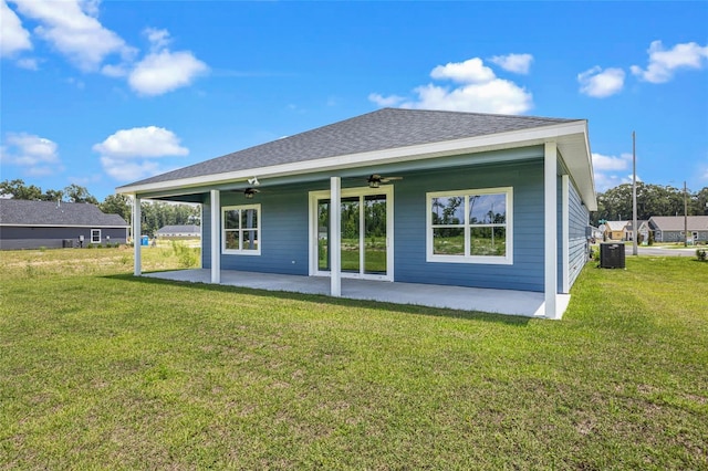 back of house featuring a shingled roof, a lawn, central AC unit, a ceiling fan, and a patio area