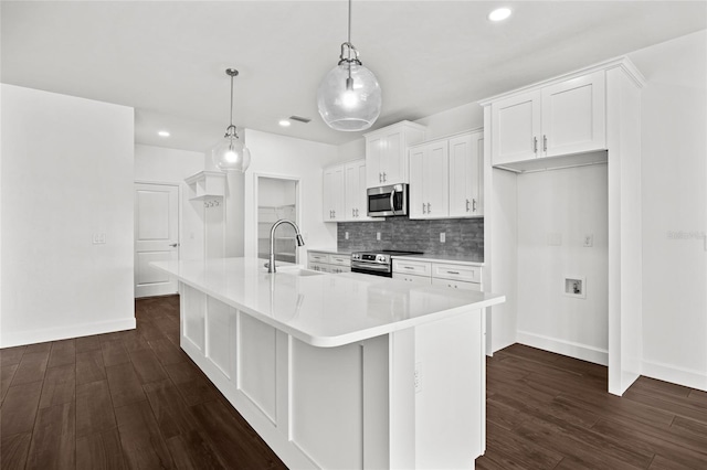 kitchen with stainless steel appliances, white cabinetry, light countertops, tasteful backsplash, and dark wood finished floors