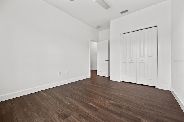 unfurnished bedroom with dark wood-style floors, visible vents, and baseboards