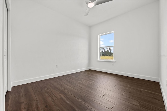 empty room featuring baseboards, dark wood finished floors, and a ceiling fan