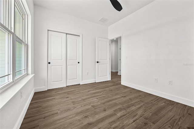 unfurnished bedroom featuring a closet, wood finished floors, and baseboards