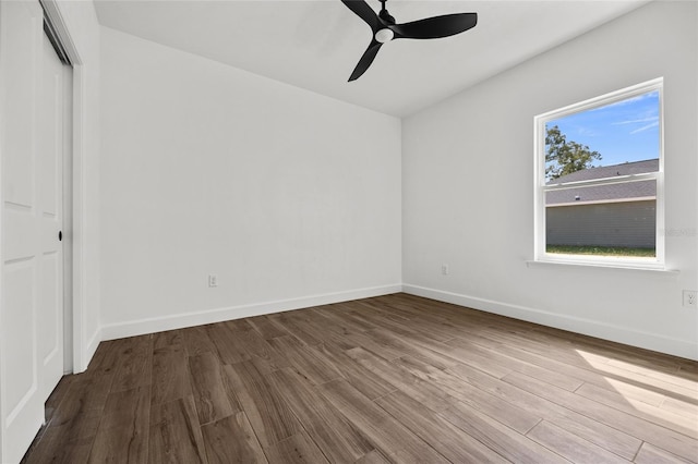 unfurnished bedroom with ceiling fan, a closet, baseboards, and wood finished floors