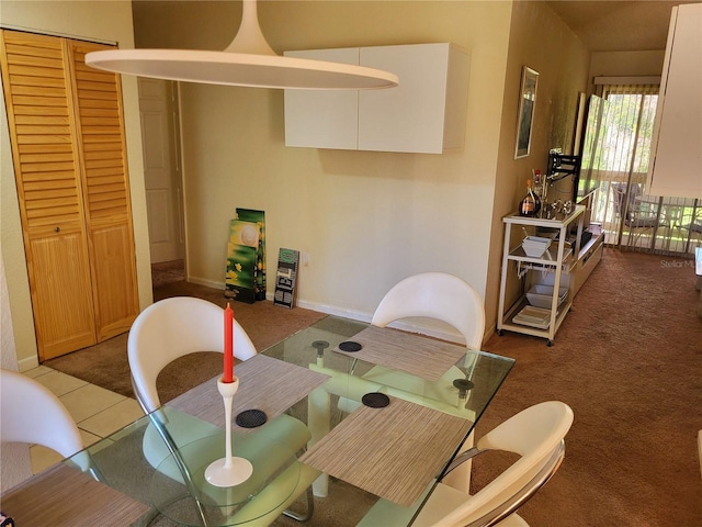 dining area with carpet floors, tile patterned flooring, and baseboards