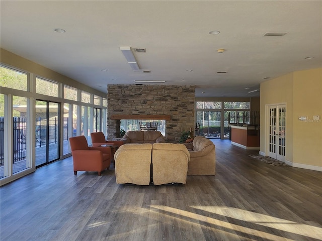 living area featuring dark wood finished floors, french doors, visible vents, and a fireplace