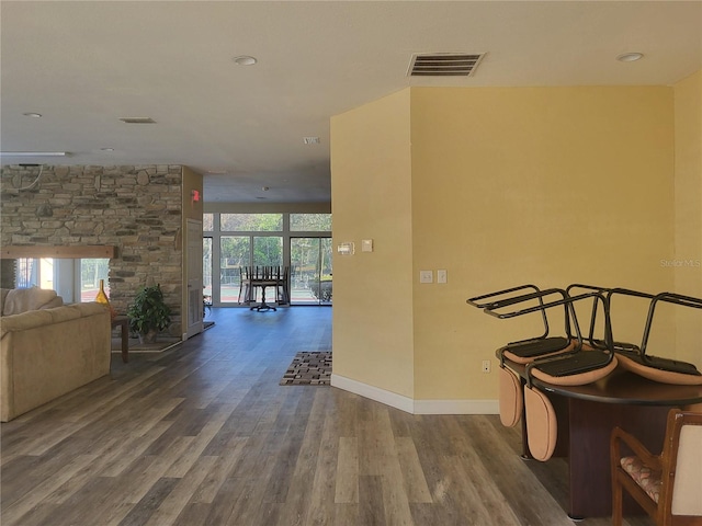 corridor with wood finished floors, visible vents, and baseboards