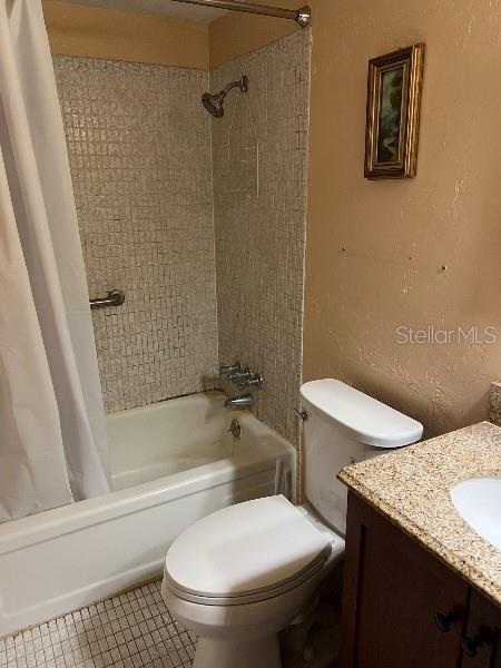 full bathroom with tile patterned floors, vanity, toilet, and shower / tub combo with curtain