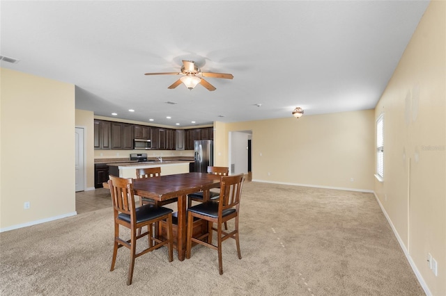 dining room featuring light carpet, baseboards, and recessed lighting