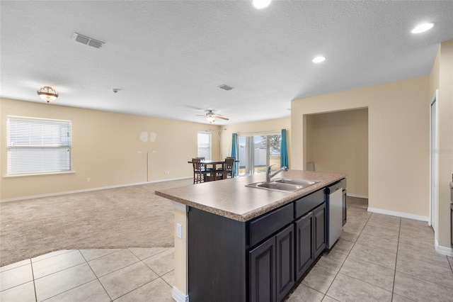 kitchen with light tile patterned floors, visible vents, light carpet, a sink, and dishwasher