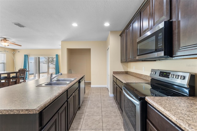 kitchen with stainless steel appliances, a sink, visible vents, and dark brown cabinetry