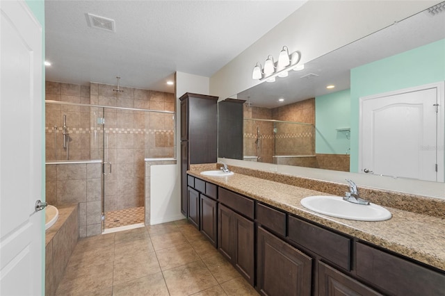 full bathroom with a stall shower, visible vents, and a sink