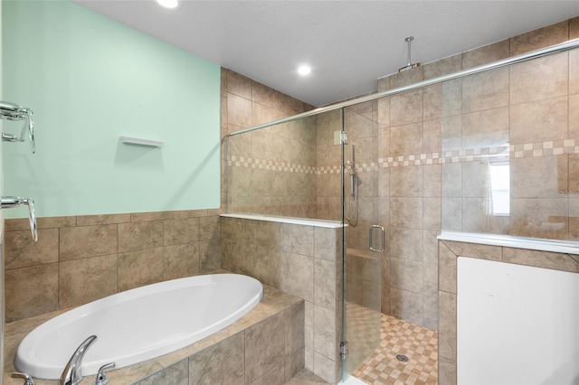 bathroom with a shower stall, a bath, and recessed lighting