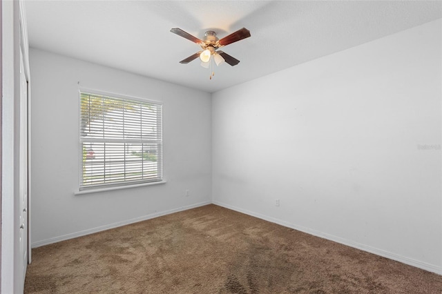 unfurnished room featuring ceiling fan, carpet, and baseboards