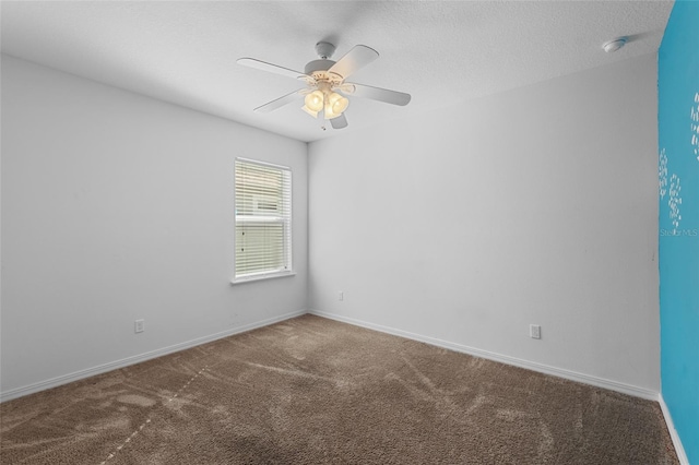 carpeted spare room featuring a ceiling fan, a textured ceiling, and baseboards