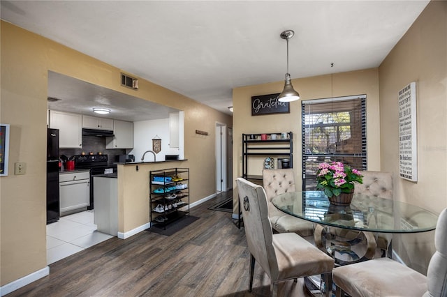 dining area featuring baseboards, visible vents, and wood finished floors